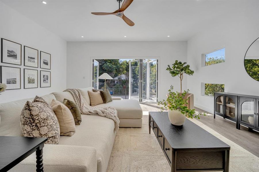 Living room with light wood-type flooring and ceiling fan