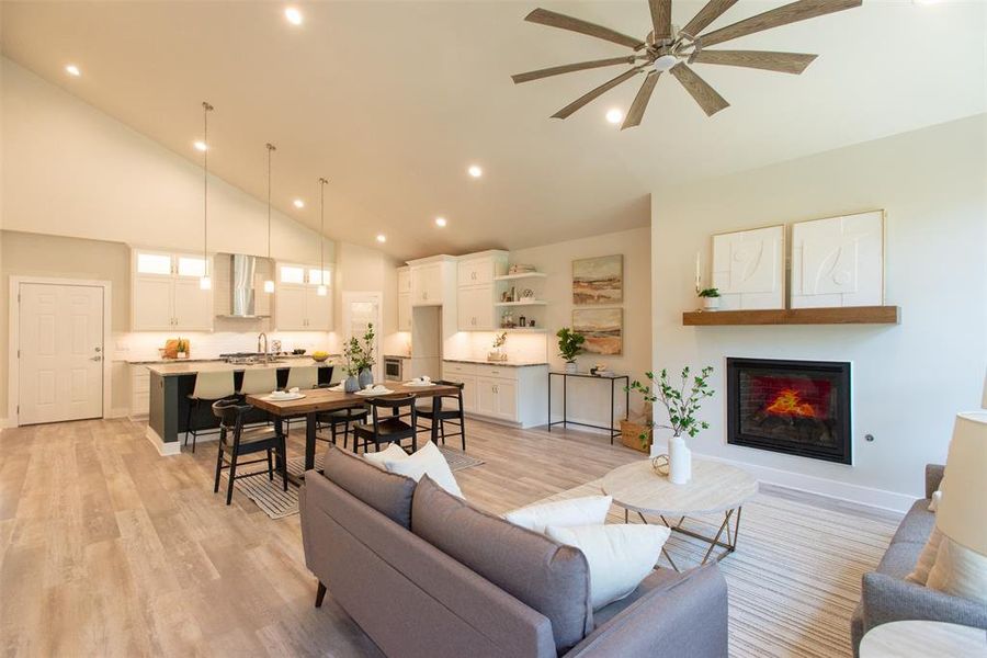 Living room featuring ceiling fan, light hardwood / wood-style floors, and high vaulted ceiling