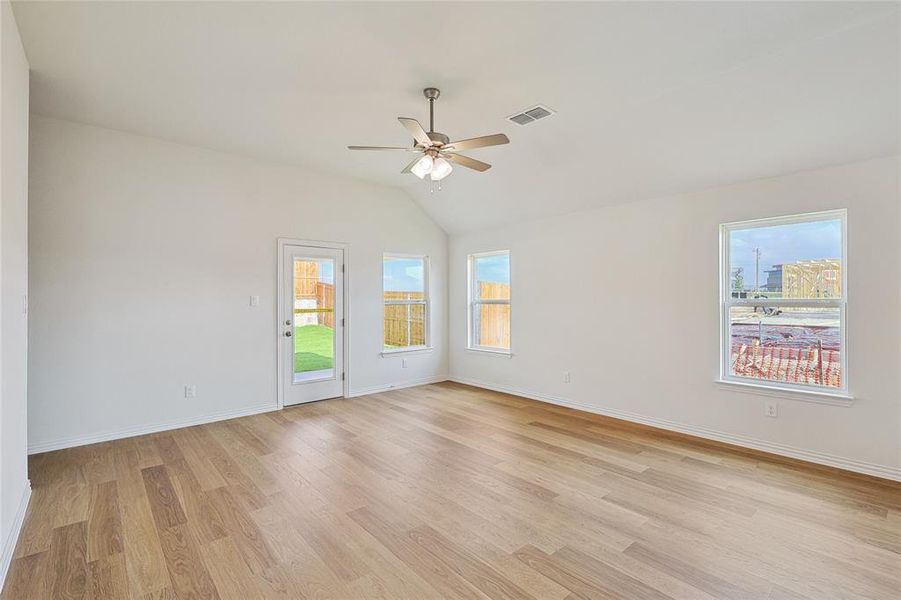 Unfurnished room featuring light wood-type flooring, lofted ceiling, and ceiling fan