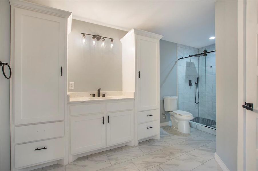 Bathroom with vanity, toilet, and a shower with shower door