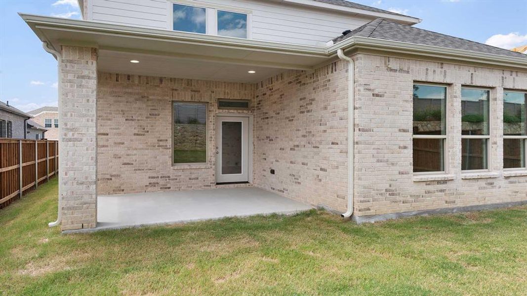 Back of house with a patio and a yard