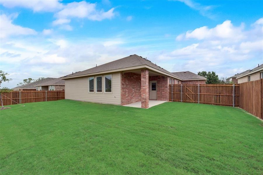 Back of house featuring a patio area and a lawn