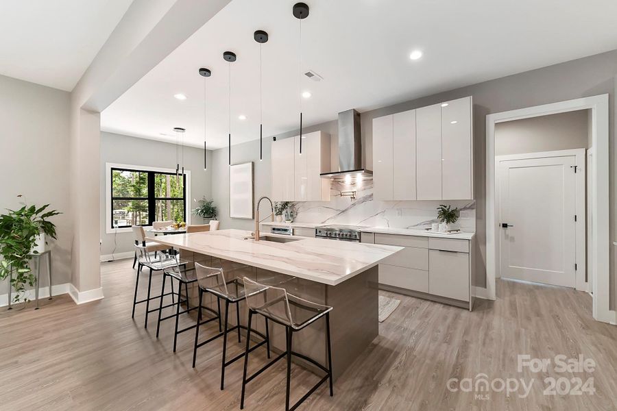 Chef's Kitchen features quartz counters, oversized island with seating/storage, 2 sinks, stainless steel appliances including 2 ovens, dishwasher & separate dishwasher drawer, Refrigerator to remain, amazing, modern cabinetry, modern, custom lighting & induction cook top!