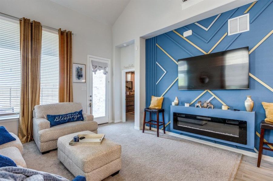 Living room featuring light hardwood / wood-style flooring, plenty of natural light, and high vaulted ceiling