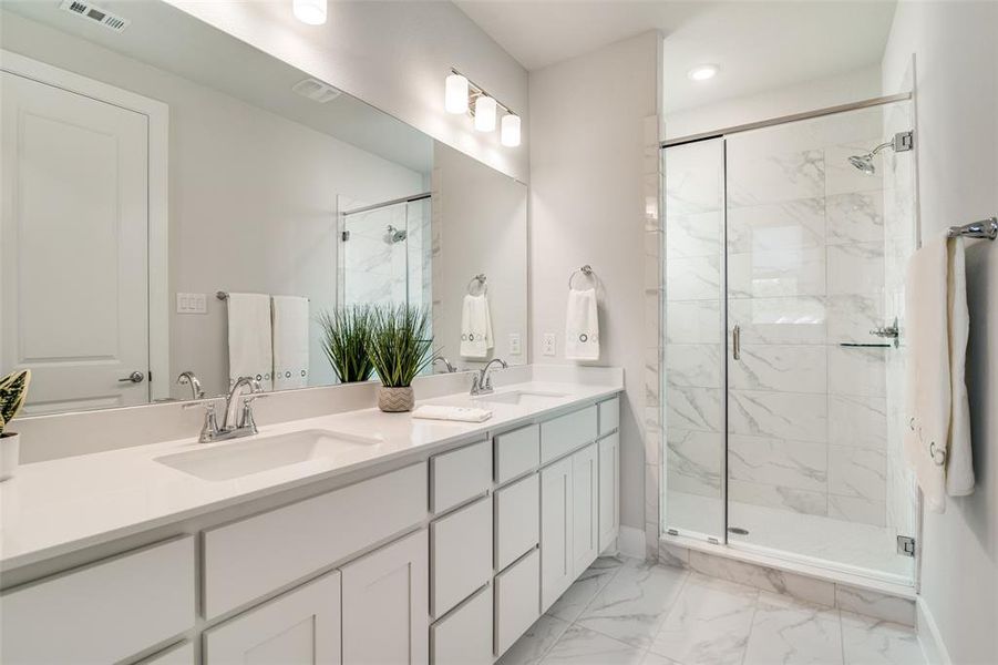 The large spacious, master bath has a shower with a seat and 12 x 24 tile used through out.  Ample storage is below the large double sink vanity.