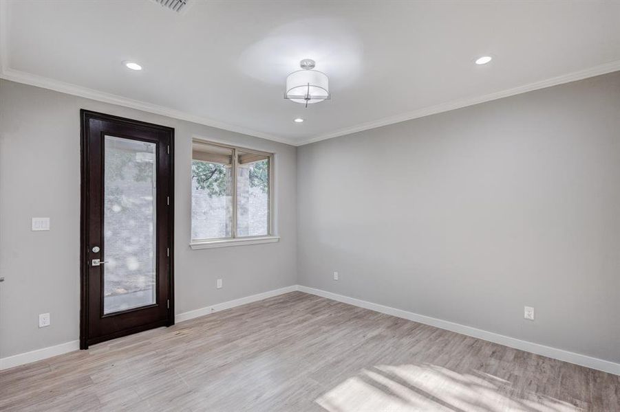 Primary room with ornamental molding and light hardwood / wood-style flooring