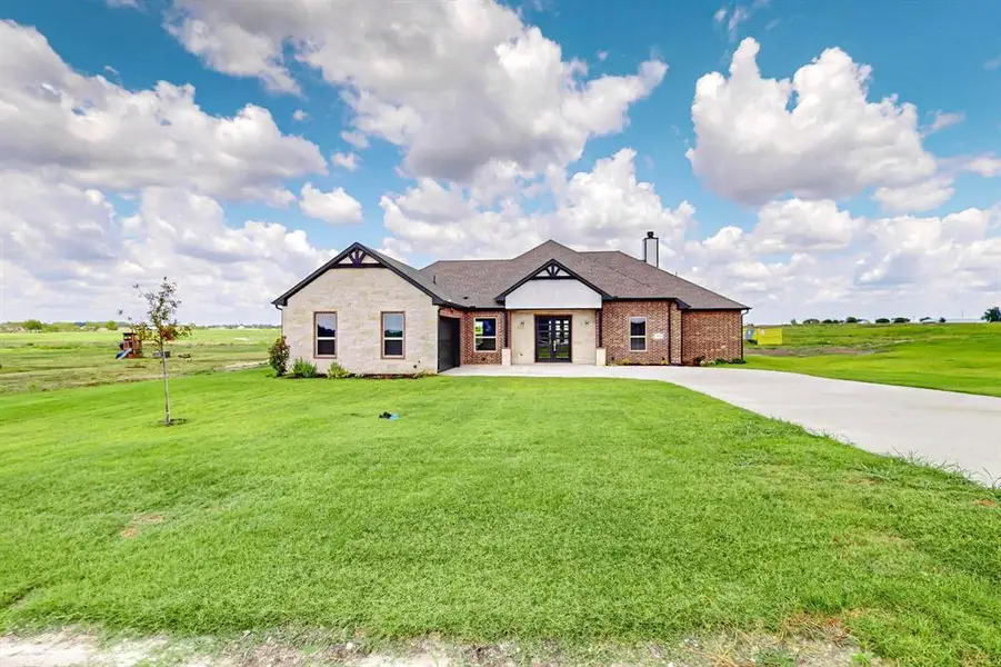 View of front of home with a front lawn and a rural view