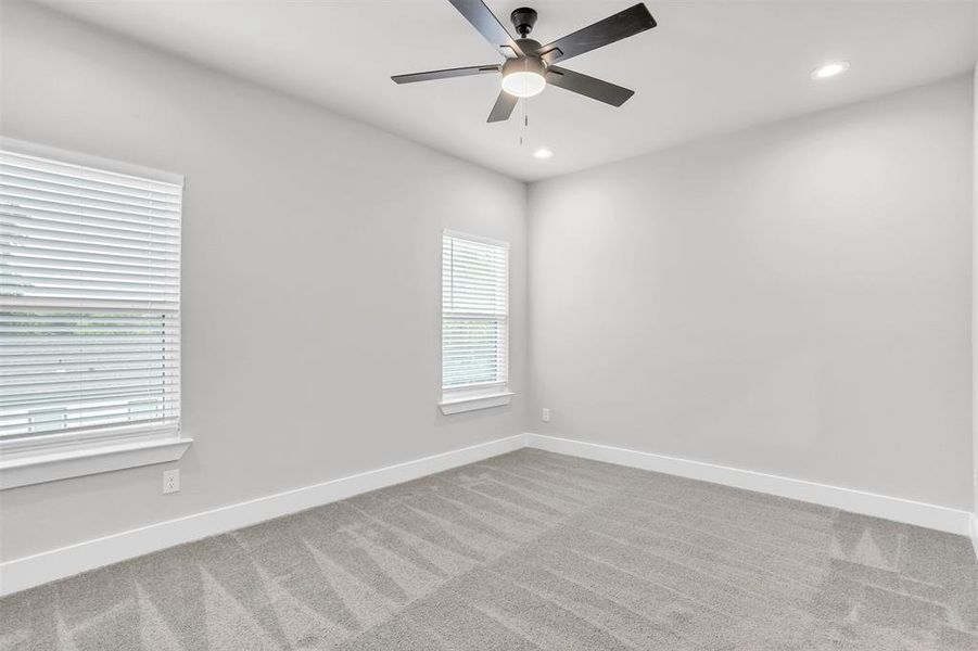 Spare room with ceiling fan and carpet floors