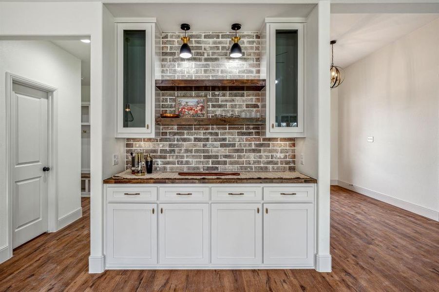 Kitchen with decorative backsplash, white cabinets, and dark hardwood / wood-style floors