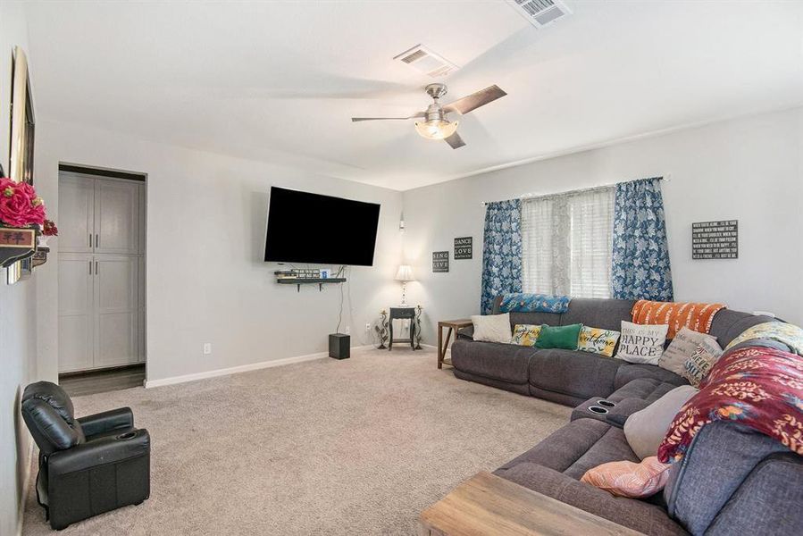 Living room featuring ceiling fan and light colored carpet