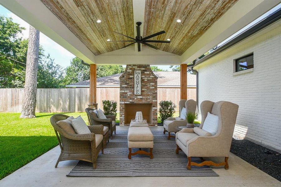 This charming brick fireplace is sure to warm outdoor entertainment under your big covered patio! This space could be easily converted to an outdoor kitchen.