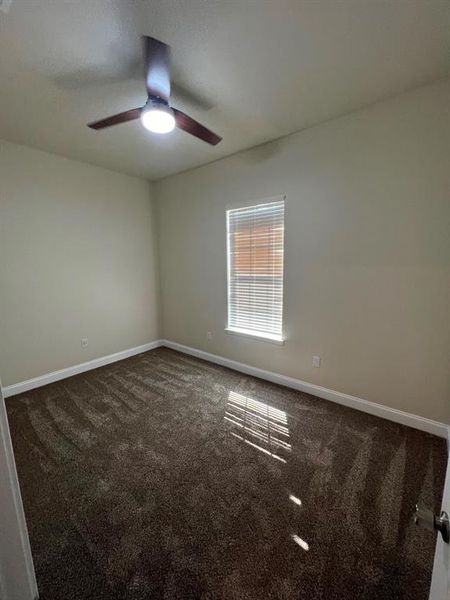 Empty room with ceiling fan and carpet