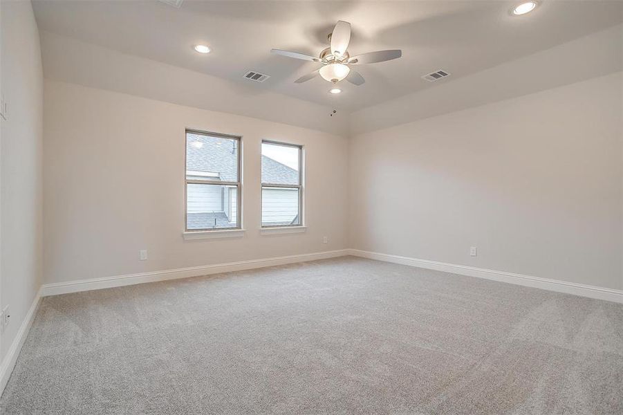 Carpeted empty room featuring ceiling fan