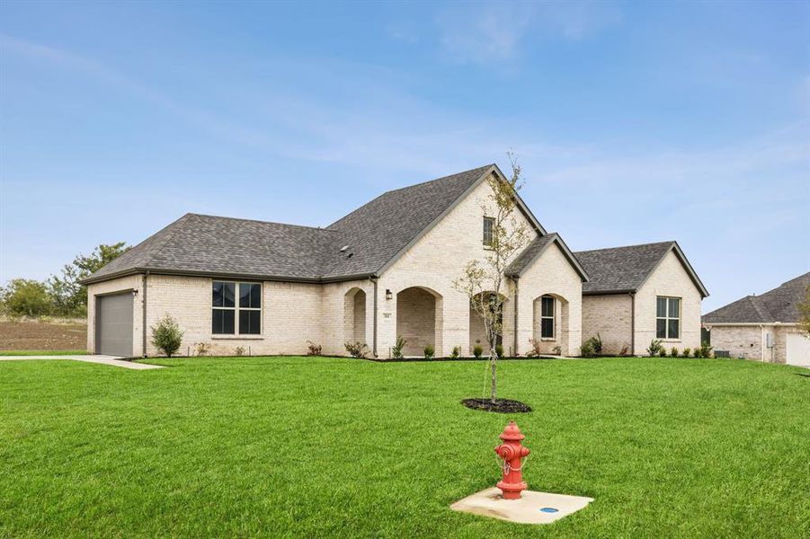 French country style house with a garage and a front yard