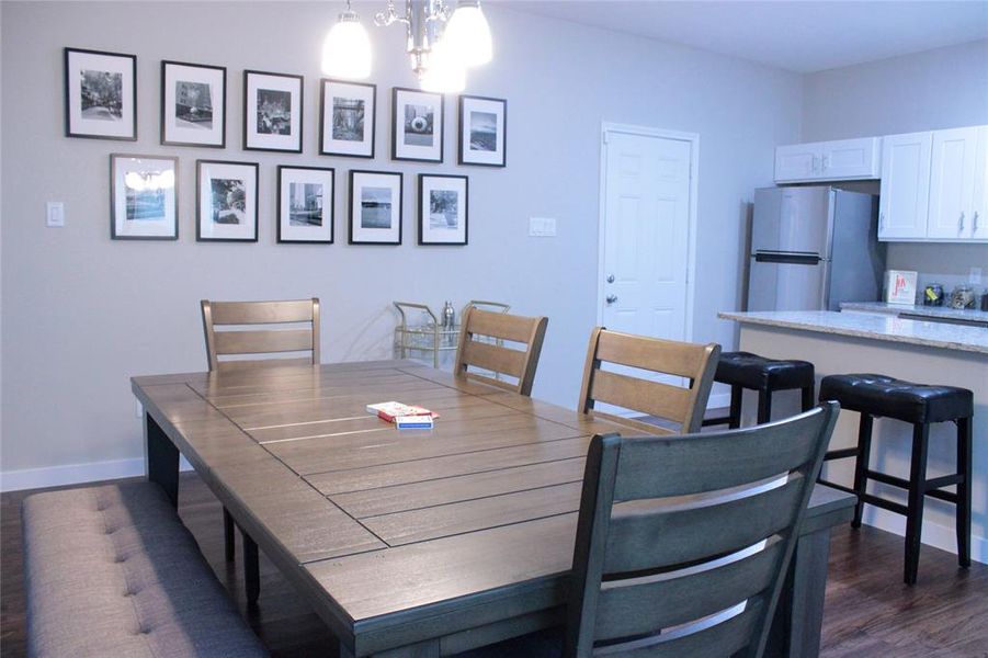 Dining area with a notable chandelier and dark hardwood / wood-style flooring