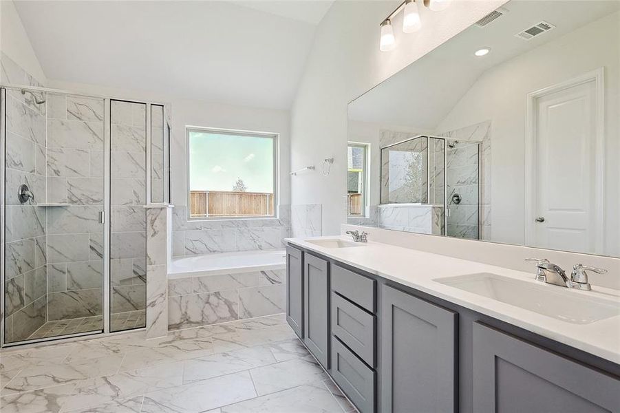 Bathroom featuring plus walk in shower, lofted ceiling, and vanity