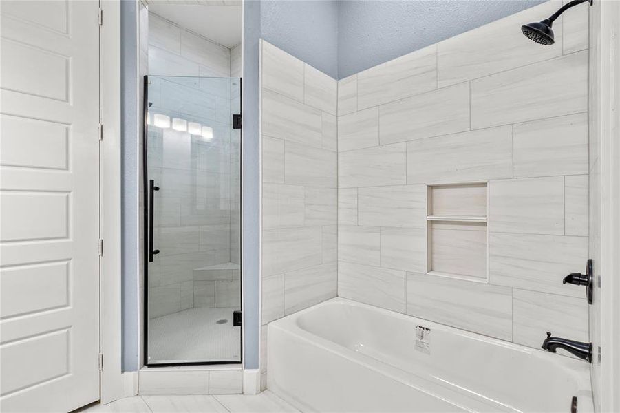 Bathroom featuring shower with separate bathtub and tile patterned floors