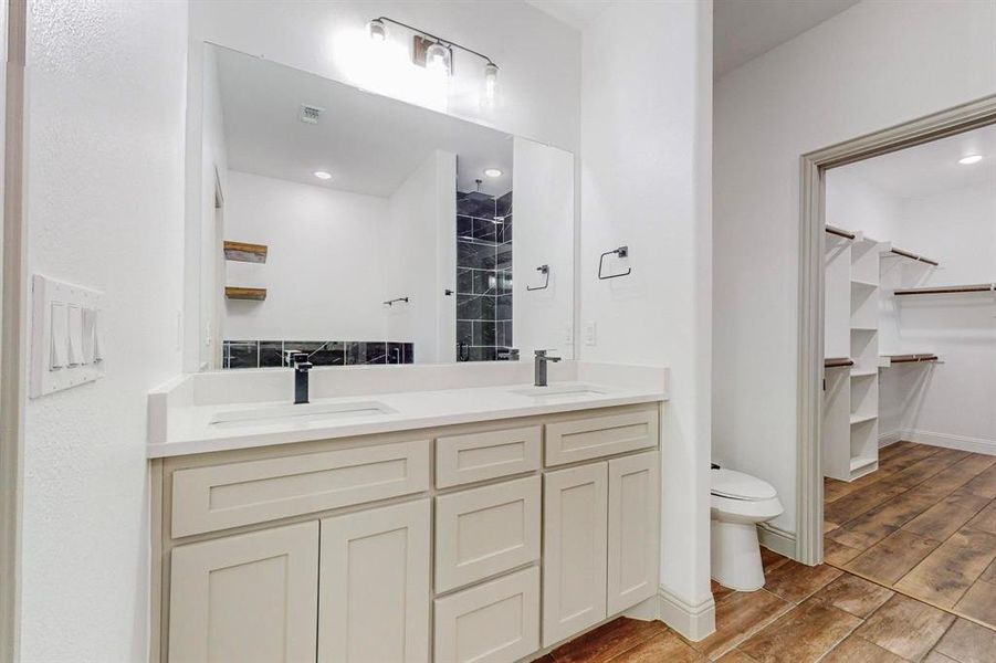 Bathroom featuring hardwood / wood-style flooring, double sink vanity, and toilet