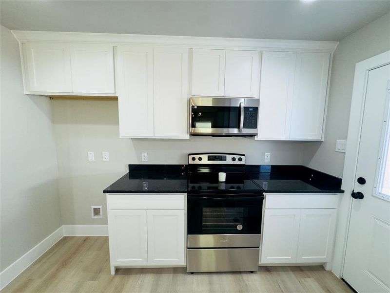 Kitchen featuring light hardwood / wood-style flooring, white cabinetry, and appliances with stainless steel finishes