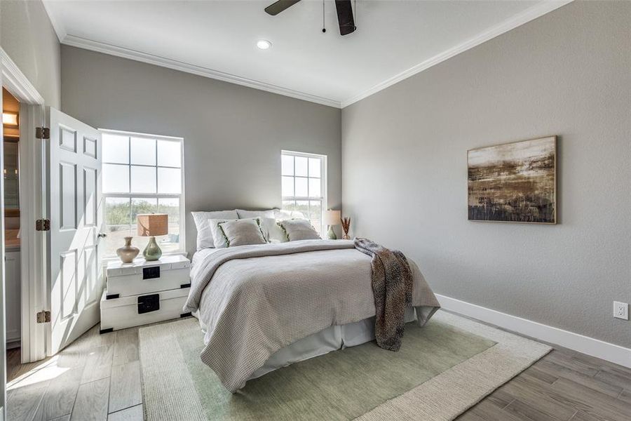 Primary Bedroom featuring hardwood / wood-style flooring, crown molding, and ceiling fan