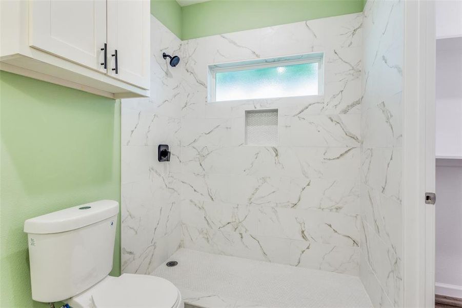 Bathroom with tiled shower and toilet