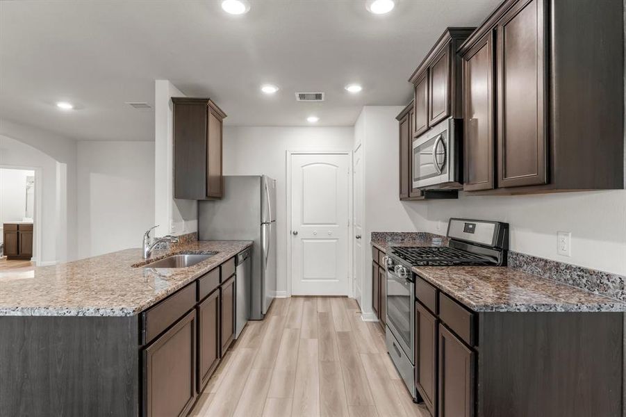 A pristine view of what this extraordinary kitchen has to offer.  Stainless steel appliances include 4 burner gas range with oven, dishwasher, microwave, and refrigerator.