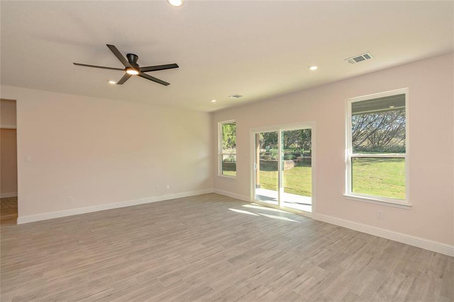 Empty room with ceiling fan and light hardwood / wood-style flooring