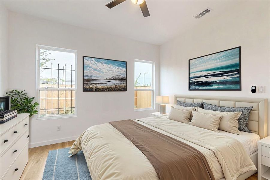 Bedroom with light wood-type flooring, multiple windows, and ceiling fan