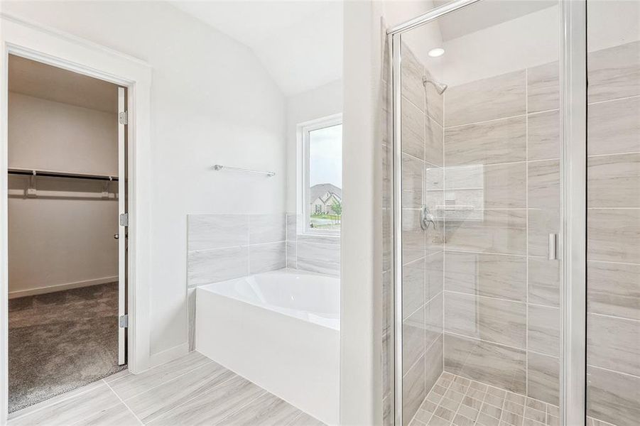 Bathroom with tile patterned floors, independent shower and bath, and vaulted ceiling