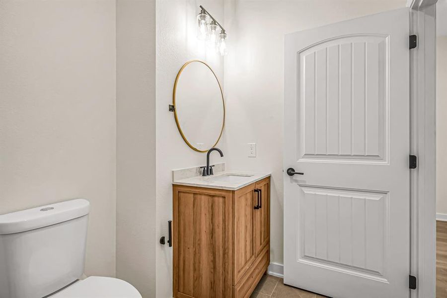 Guest bath with stained wood vanity.