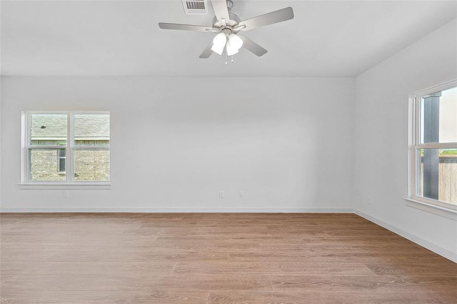 Empty room with light hardwood / wood-style floors and ceiling fan