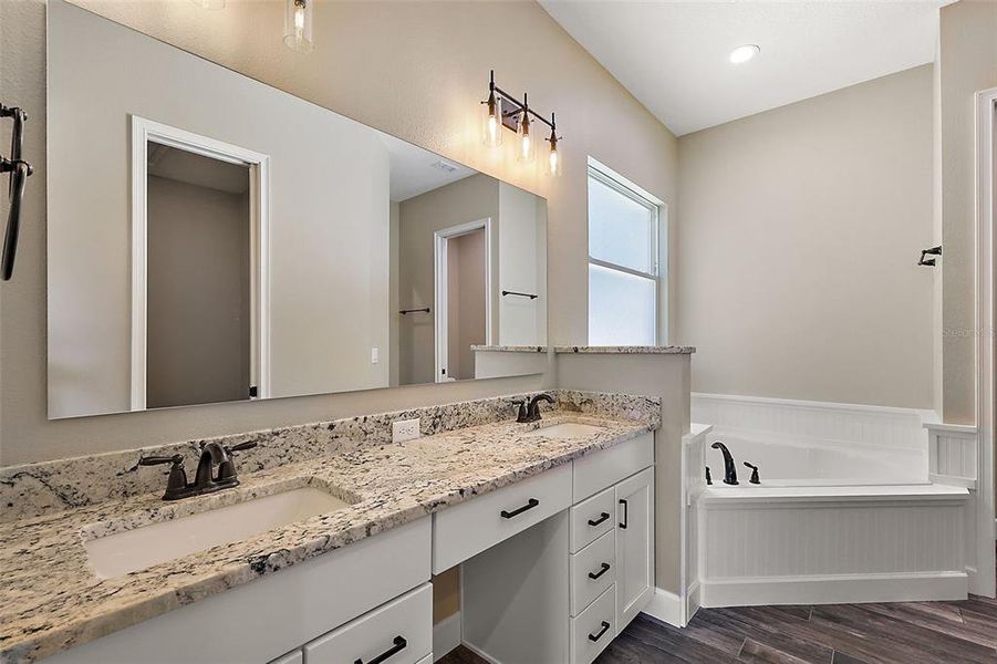 En-suite bath with dual sinks, Granite, soaking tub, and separate tiled shower