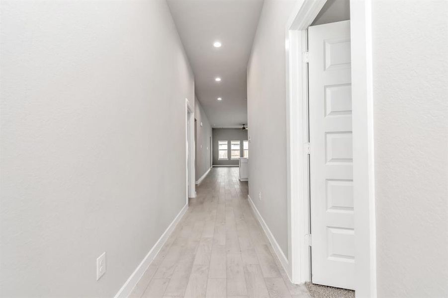 Greeted by a elegant glass front door, the entrance beckons with high ceilings, adorned with elegant wood-look tile flooring and oversized baseboards. Sample photo of completed home with similar floor plan. As-built interior colors and selections may vary.