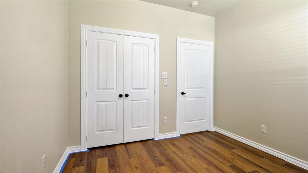 Unfurnished bedroom featuring a closet and dark wood-type flooring