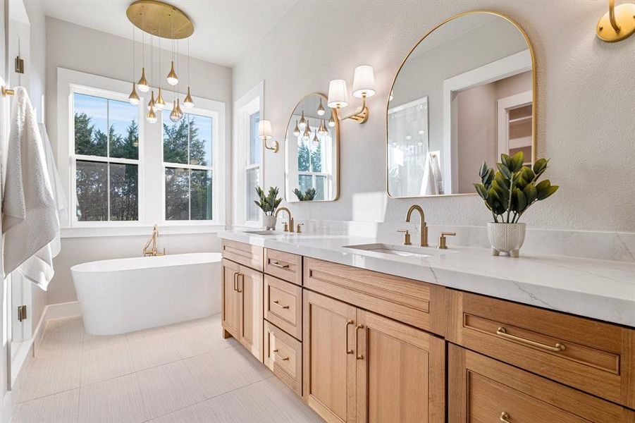 Bathroom featuring a bath, dual bowl vanity, tile flooring, and a chandelier