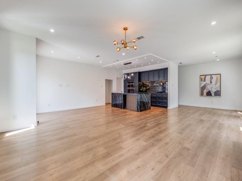 Unfurnished living room featuring light hardwood / wood-style flooring and a chandelier