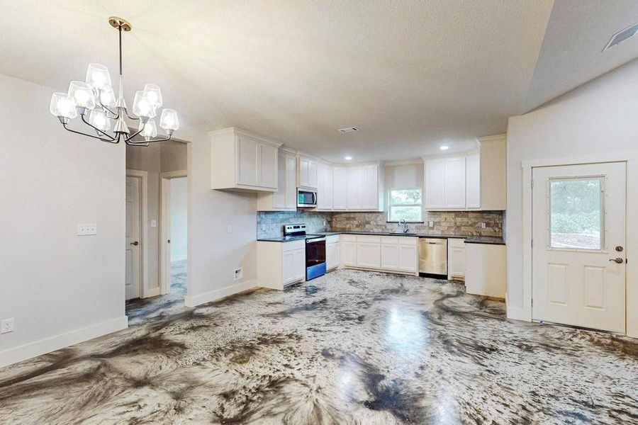 Kitchen featuring white cabinetry, hanging light fixtures, a healthy amount of sunlight, and appliances with stainless steel finishes