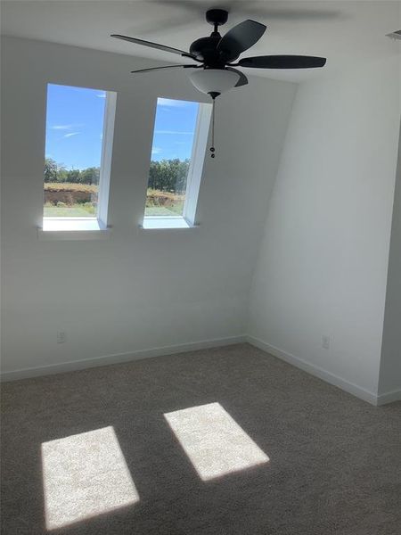 Carpeted empty room with ceiling fan