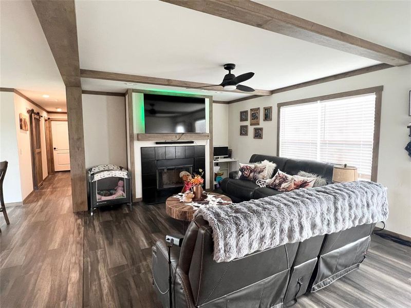 Living room featuring ornamental molding, dark hardwood / wood-style floors, a fireplace, and ceiling fan