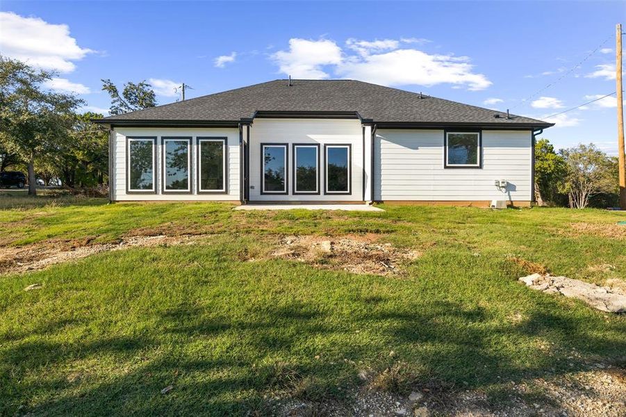 Rear view of property with a yard