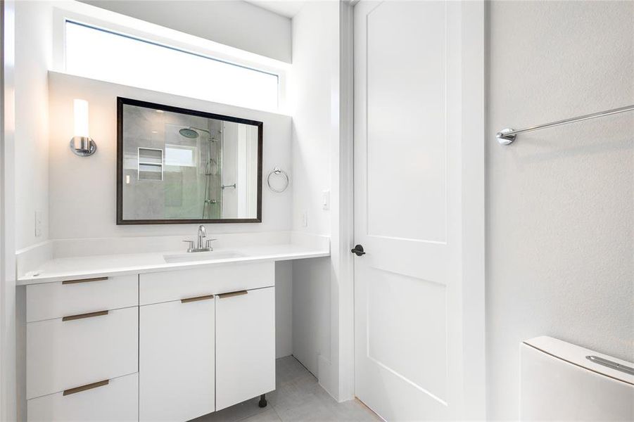 Bathroom featuring vanity, tile patterned flooring, and toilet