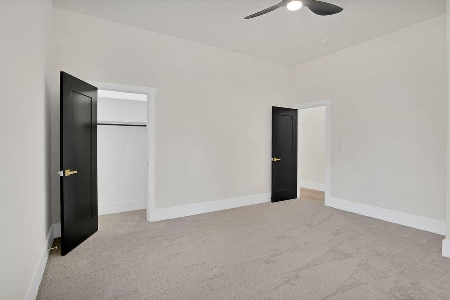 Unfurnished bedroom with ceiling fan and light carpet