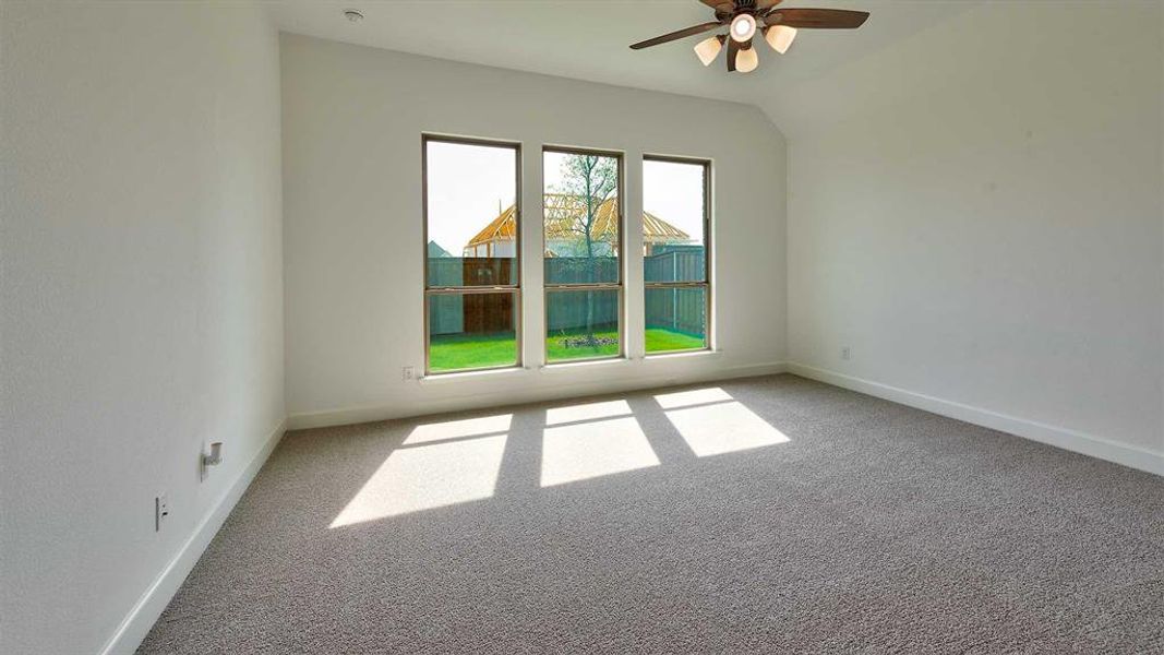 Unfurnished room with carpet, ceiling fan, and vaulted ceiling