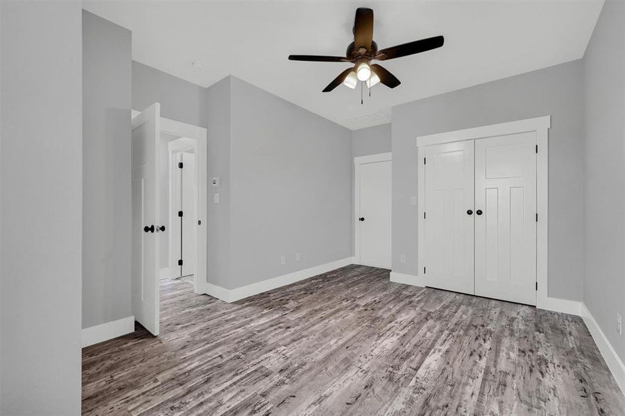 Unfurnished bedroom with ceiling fan, light wood-type flooring, and a closet