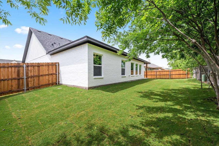 Rear view of property with a yard