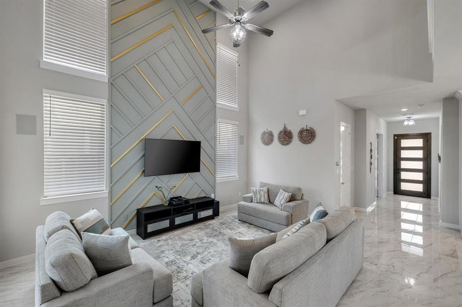 Tiled living room featuring a towering ceiling and ceiling fan