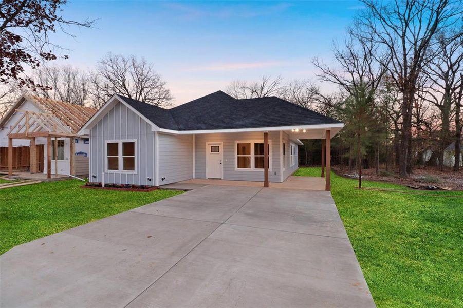 Single story home with a carport and a yard