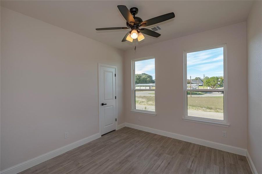 Unfurnished room with ceiling fan and light hardwood / wood-style flooring