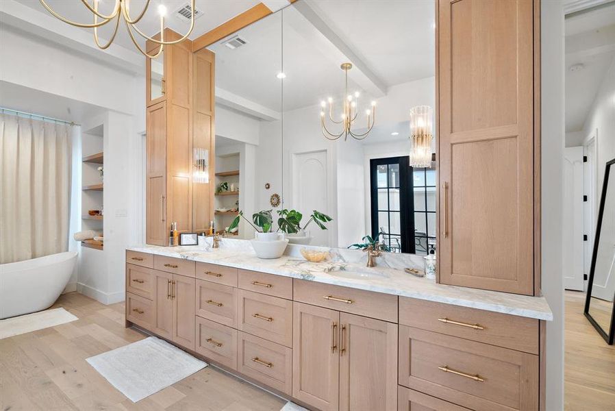 Bathroom featuring beamed ceiling, wood-type flooring, a notable chandelier, and dual vanity