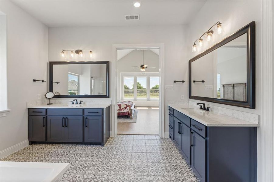 Bathroom with lofted ceiling, vanity, and ceiling fan